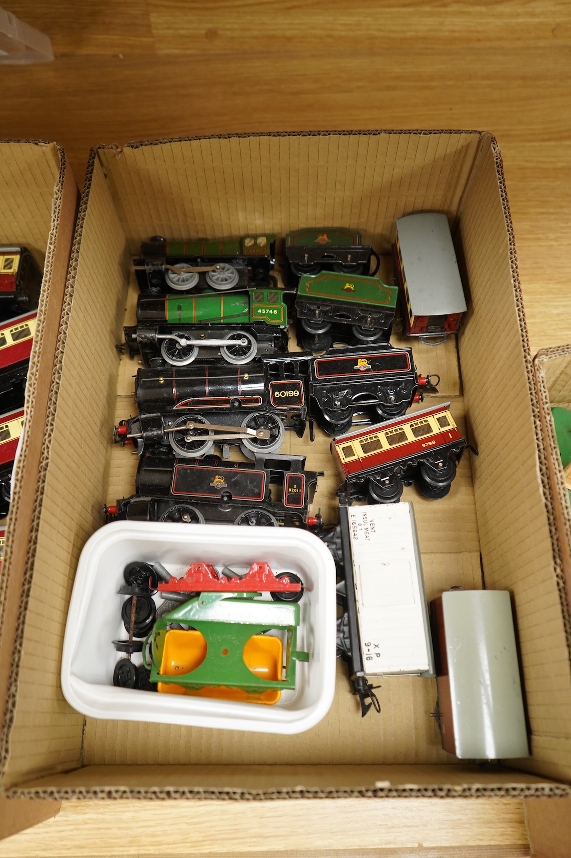 A collection of 0 gauge Hornby tinplate clockwork railway, including four BR locomotives, 17 freight wagons and four wheel coaches, together with a station building, signal cabin, and Goods depot (missing base), plus a f